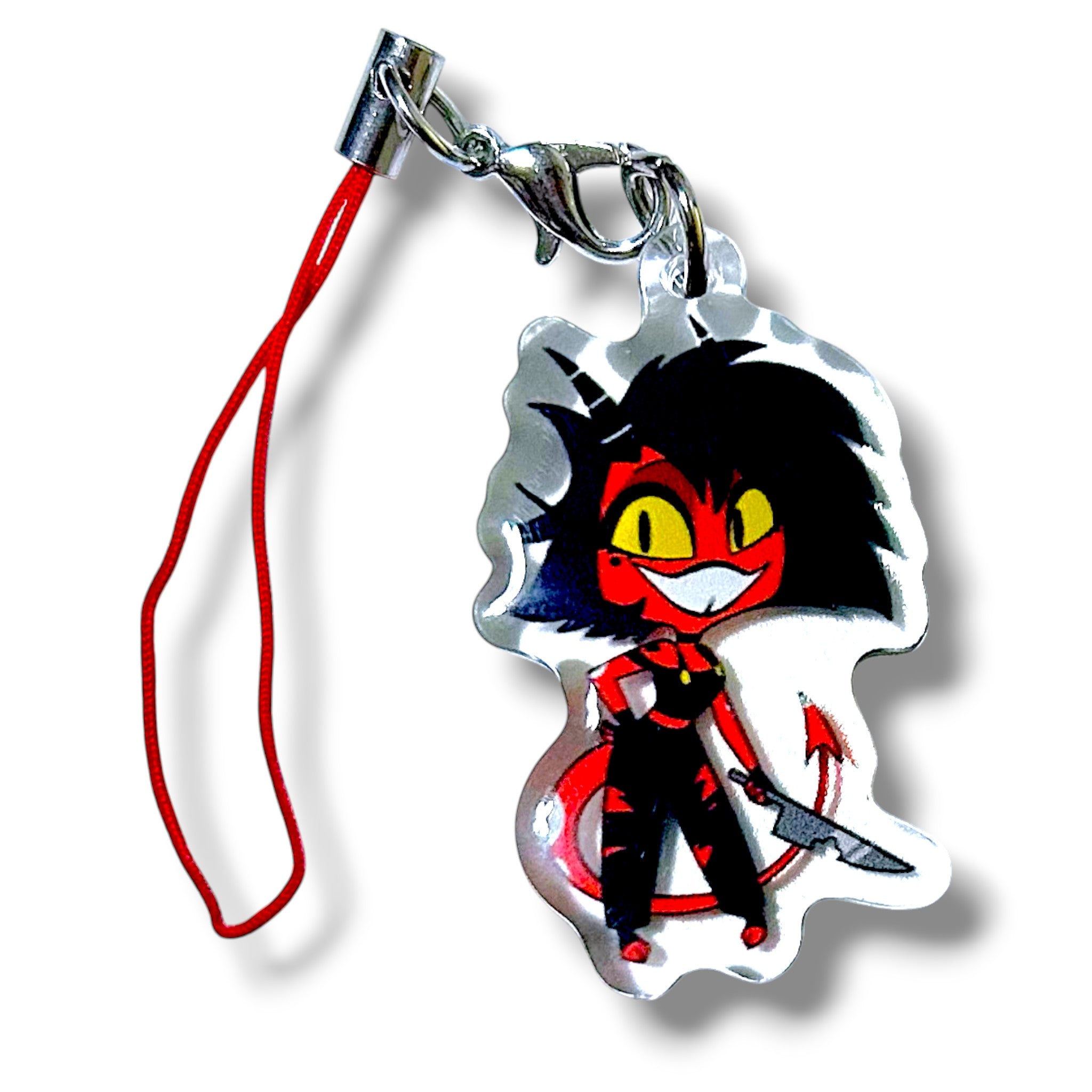 Stylized acrylic keychain charm featuring a red-skinned cartoon character with bright yellow eyes, spiky black hair, and a mischievous expression. The character holds a curved knife in its right hand and has a pointed tail, dressed in black pants and a black top with red accents. The charm is attached to a red strap with a silver clasp, making it a bold and collectible accessory for fans of animated assassin themes.