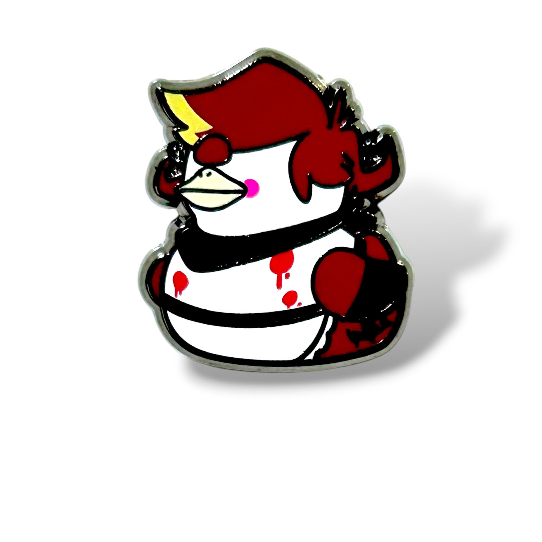 Cartoon-style enamel pin of a duck reimagined as a baby cyclops character. The duck has a red head with a yellow crest, pink cheeks, and a single large black eye with a small red mark below it. Its body is mostly white with bold black stripes and red wings, accented by dramatic red splatter details across the chest. Outlined in black with a glossy enamel finish, the design is striking, whimsical, and perfect for collectors of bold, themed pin