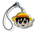 Cartoon-style keychain charm featuring a character head with a yellow straw hat and red band. The character has large, expressive eyes, black hair, and a small scar under the left eye. The charm is made of acrylic and attached to a black strap with a silver clasp. The design evokes a playful pirate theme with anime-inspired features, making it a collectible accessory for fans of adventurous characters.