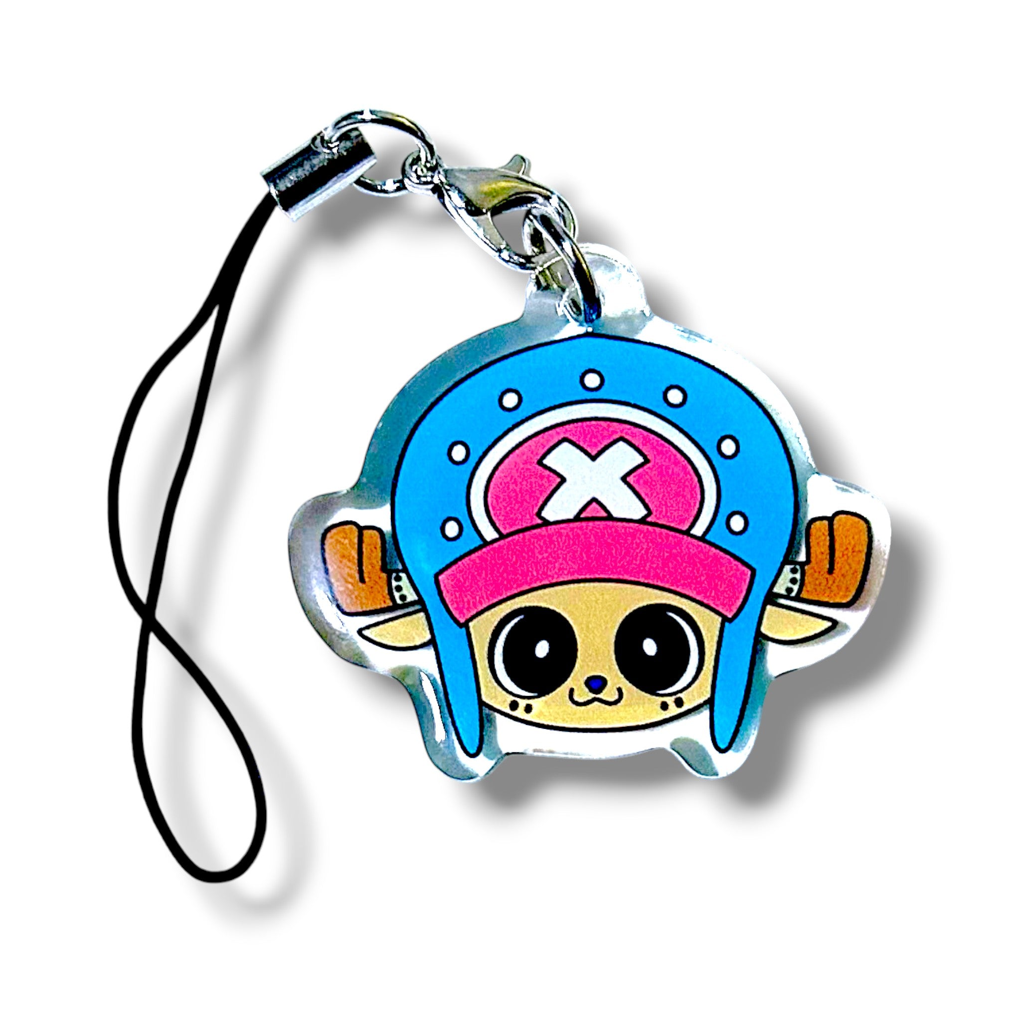 Cartoon-style acrylic keychain charm featuring a tan-faced character with large round eyes, a blue helmet with a pink "X" on the front, and brown antlers. The character has a cheerful smile and is attached to a black strap with a silver clasp. The design evokes a playful reindeer doctor aesthetic inspired by anime, making it a fun and collectible accessory.