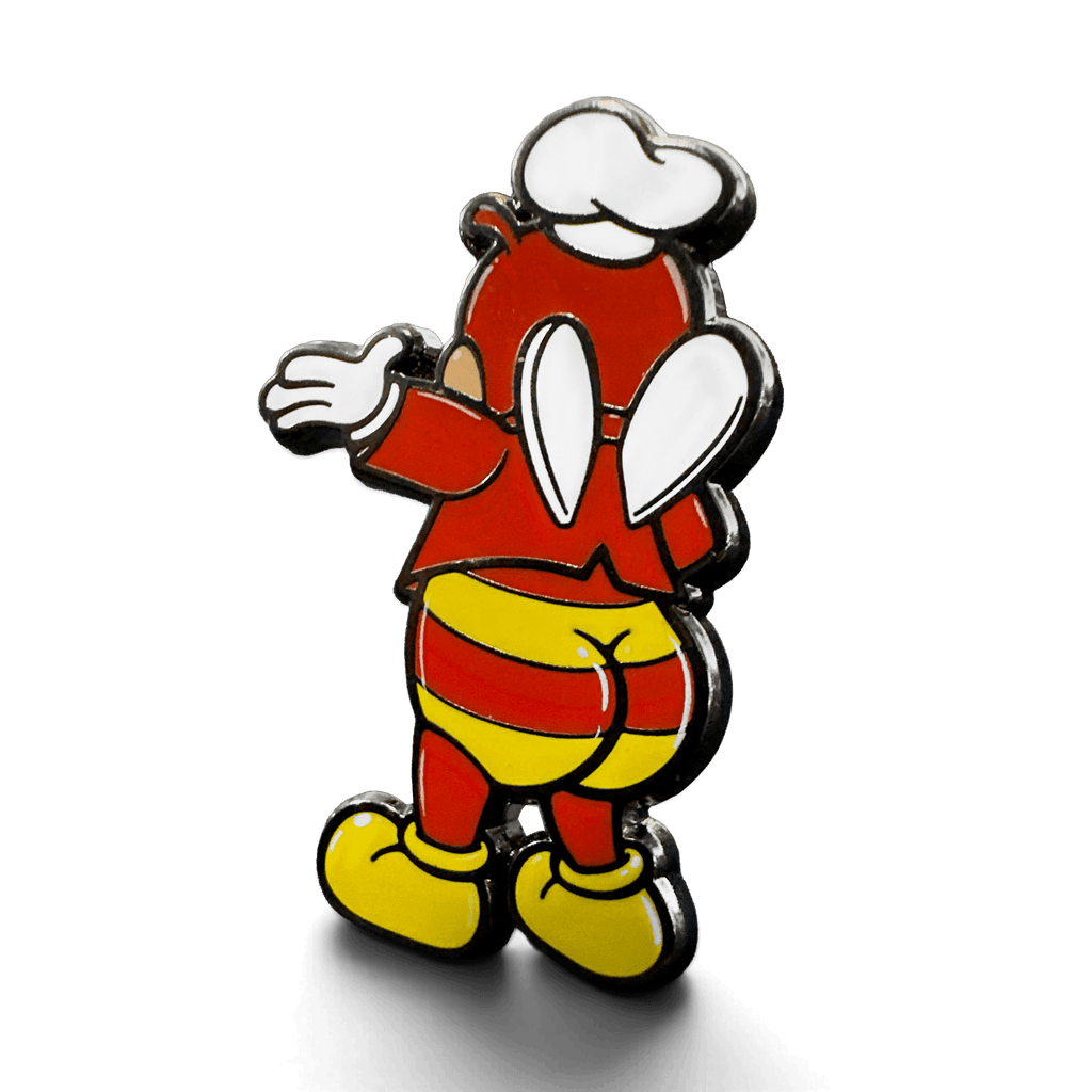 Angled view of the Jolli-Butt enamel pin featuring a red character with white gloves and goggles, yellow striped shorts, and yellow boots on a white background.