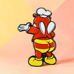 Jolli-Butt enamel pin showing a red character from behind in striped shorts, yellow shoes, and a white chef’s hat against a pastel yellow and peach background.