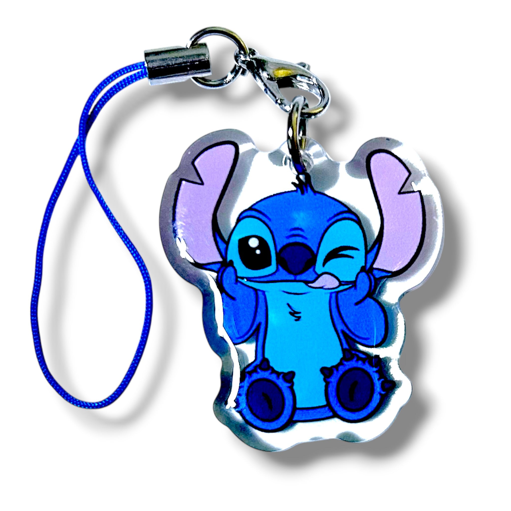Acrylic keychain charm featuring Stitch from “Lilo & Stitch” in a playful pose. Stitch is winking and holding up one hand in a peace sign-like gesture. The character is rendered in blue and purple tones with bold black outlines. The charm is attached to a blue strap with a silver clasp, making it a fun and collectible accessory for fans of Disney’s favorite experiment.