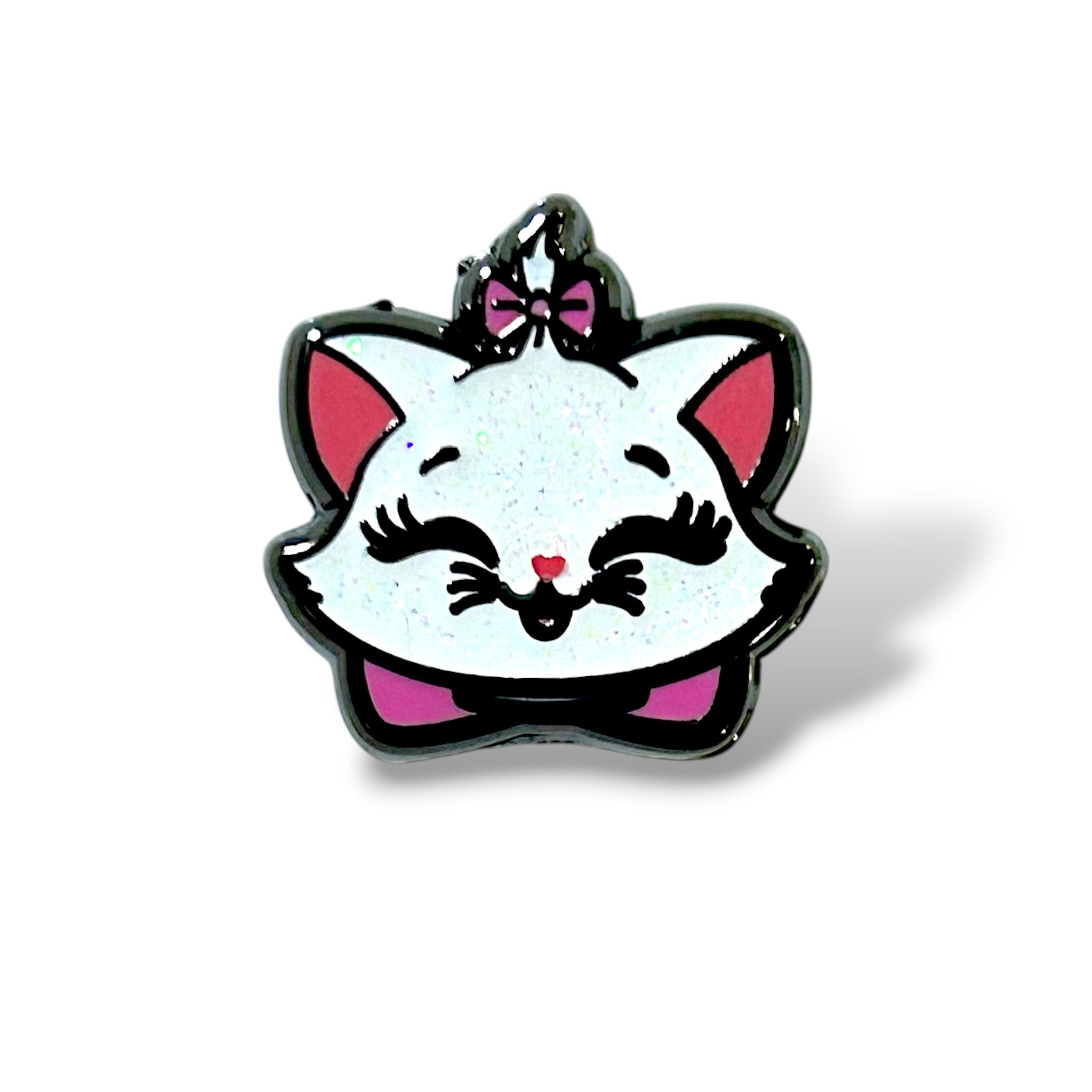 Enamel pin featuring a glittery white cartoon kitten face with large pink ears, closed eyes with long black lashes, a small pink nose, and a wide smiling mouth. The kitten has a pink bow on top of its head and another pink bow below its chin, outlined in black for bold contrast—designed in a playful, character-inspired style with a cheerful and cute expression.