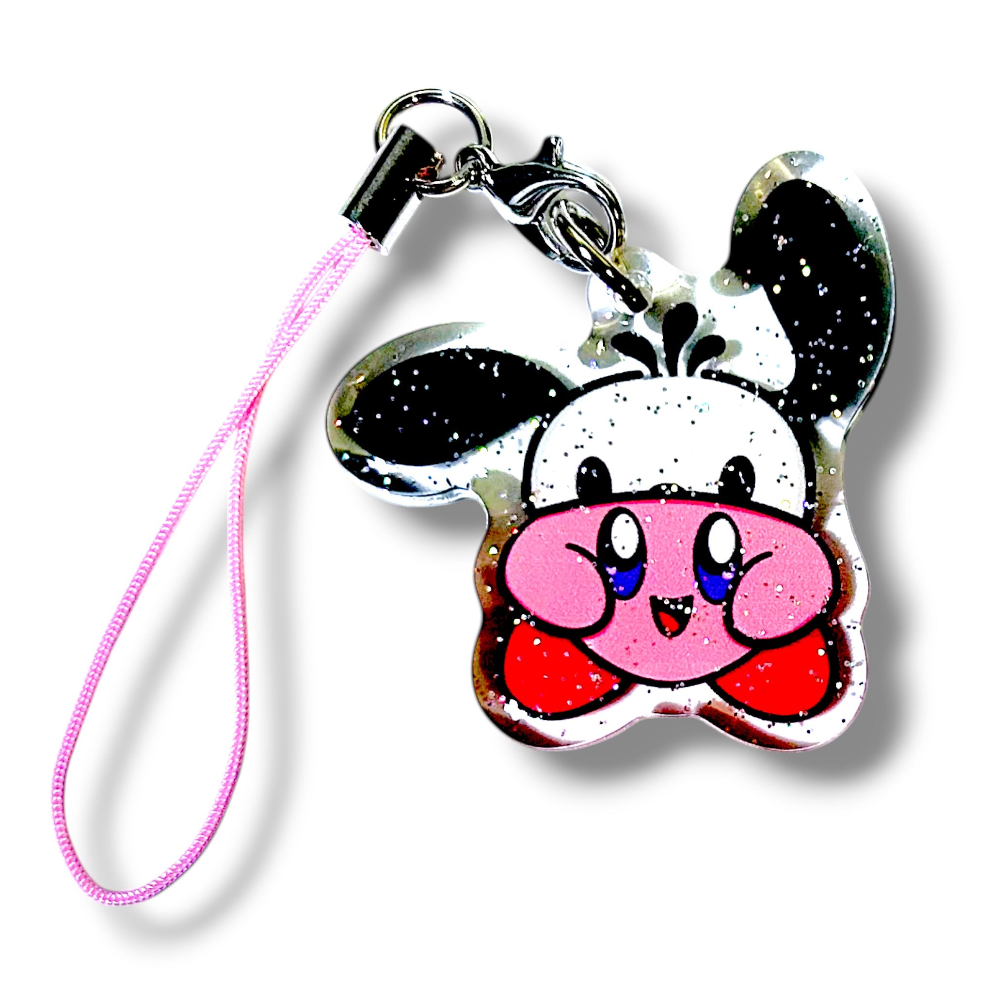 Kawaii-style keychain charm featuring a mashup character inspired by Kirby and a panda. The charm has Kirby’s round pink face and red feet, with panda-like black ears and eye markings. It’s attached to a pink strap with a metal clasp. The background of the charm includes a glittery effect, adding sparkle to the playful design. This accessory blends gamer flair with panda cuteness, making it a fun and collectible item.