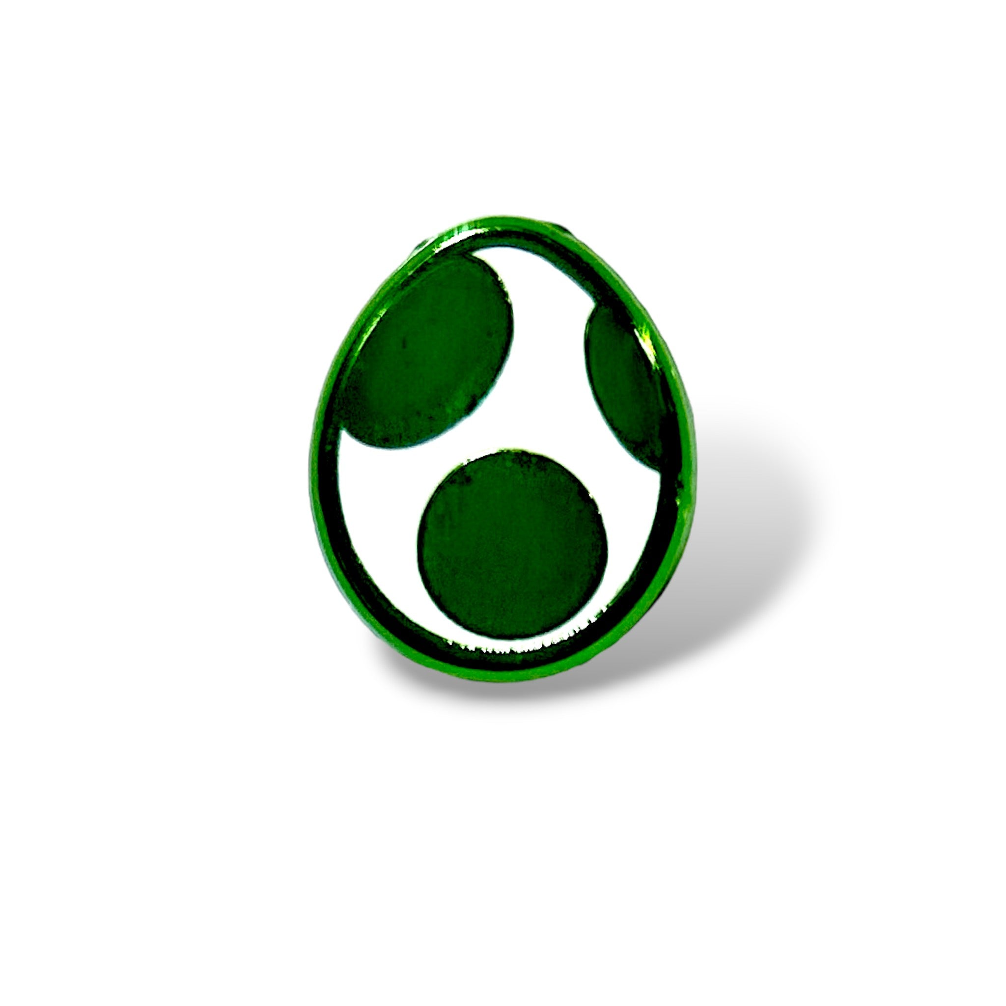 Enamel pin shaped like a white egg with three large green spots, glossy finish and soft shadowing; designed in a cartoon style inspired by classic gaming collectibles, resembling a dino egg power-up.