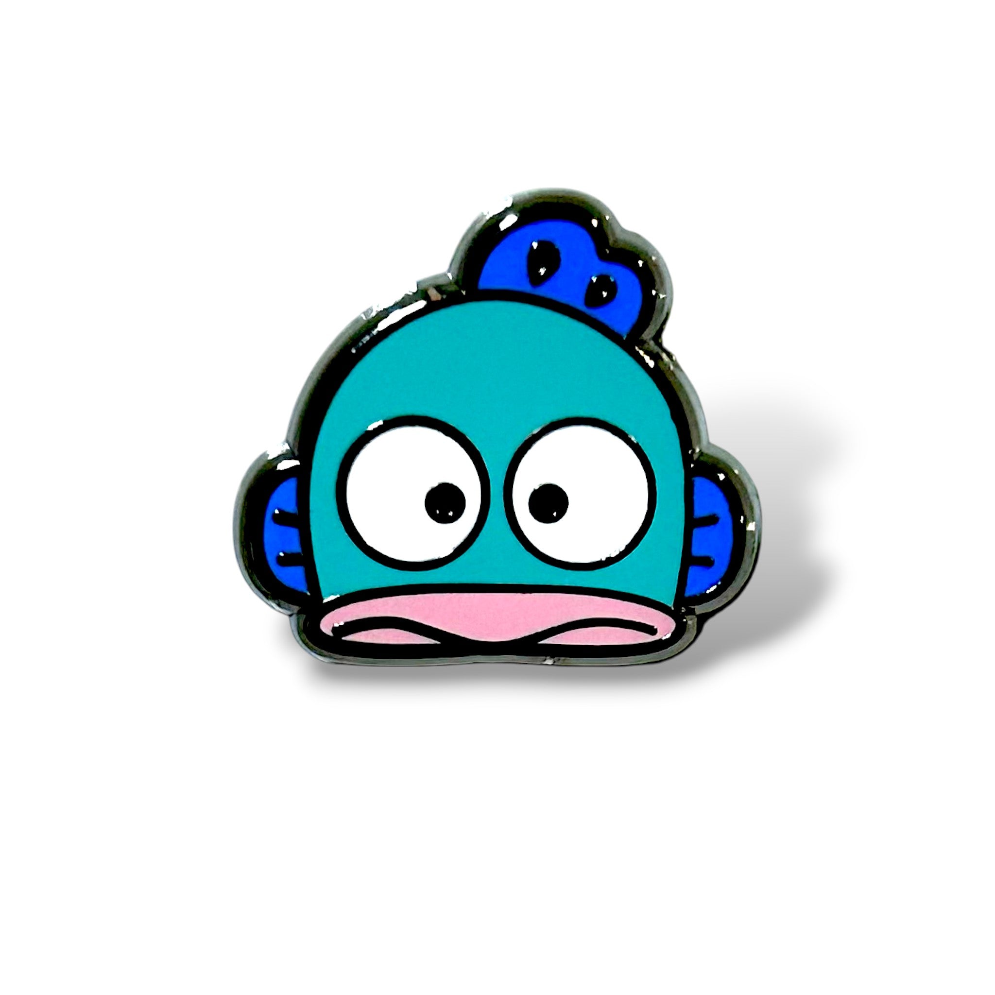 Cartoon-style enamel pin of a turquoise blue fish head with large, round white eyes and black pupils, giving a surprised expression. The fish has a pink horizontal mouth, dark blue side fins, and a blue crest fin on top of its head. The design is outlined in black with a glossy finish, capturing a playful and quirky kawaii aesthetic.