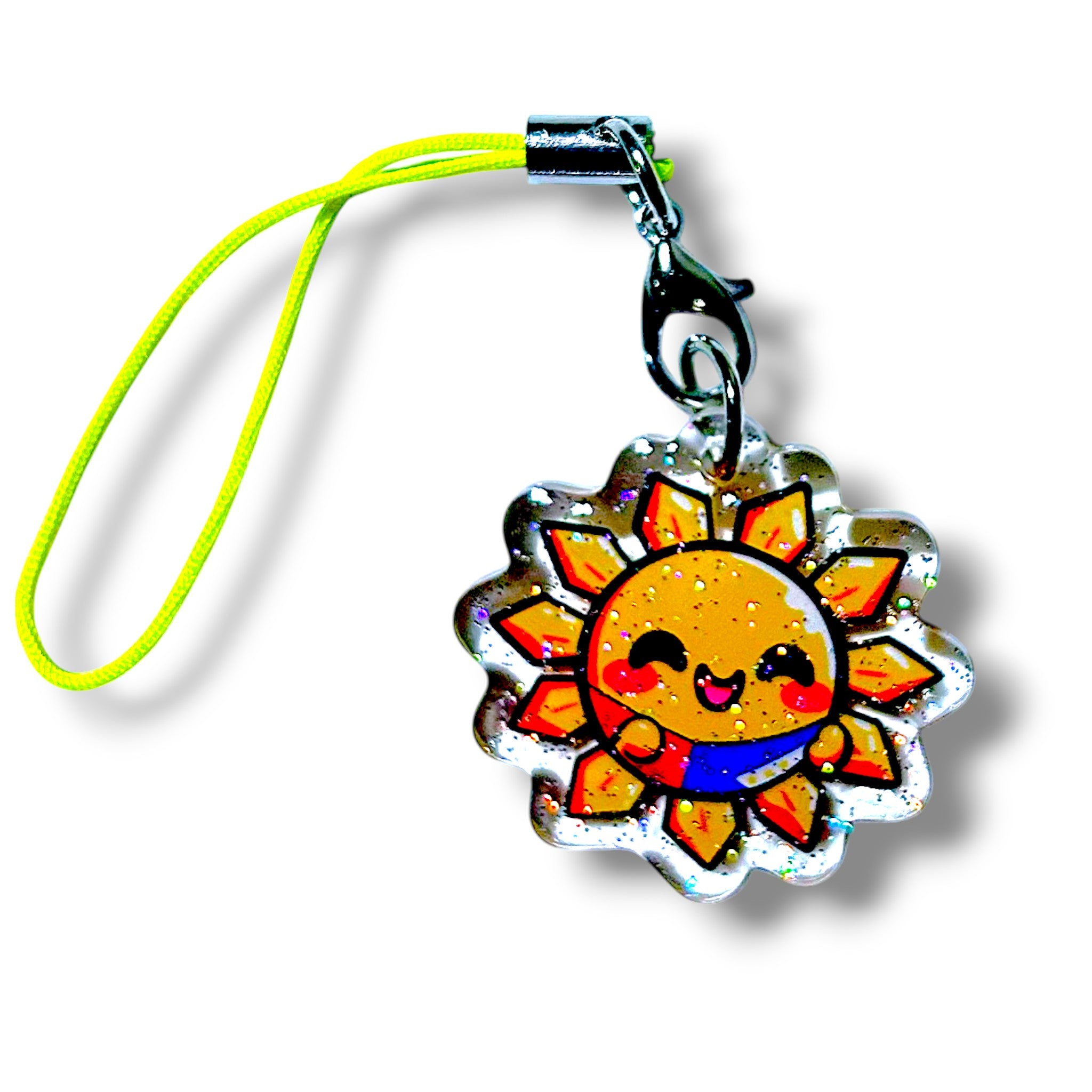 Cute cartoon-style sun charm with a smiling face, glittery finish, and red, blue, and yellow flag detail, attached to a yellow strap and metal clasp for phone or bag accessories.