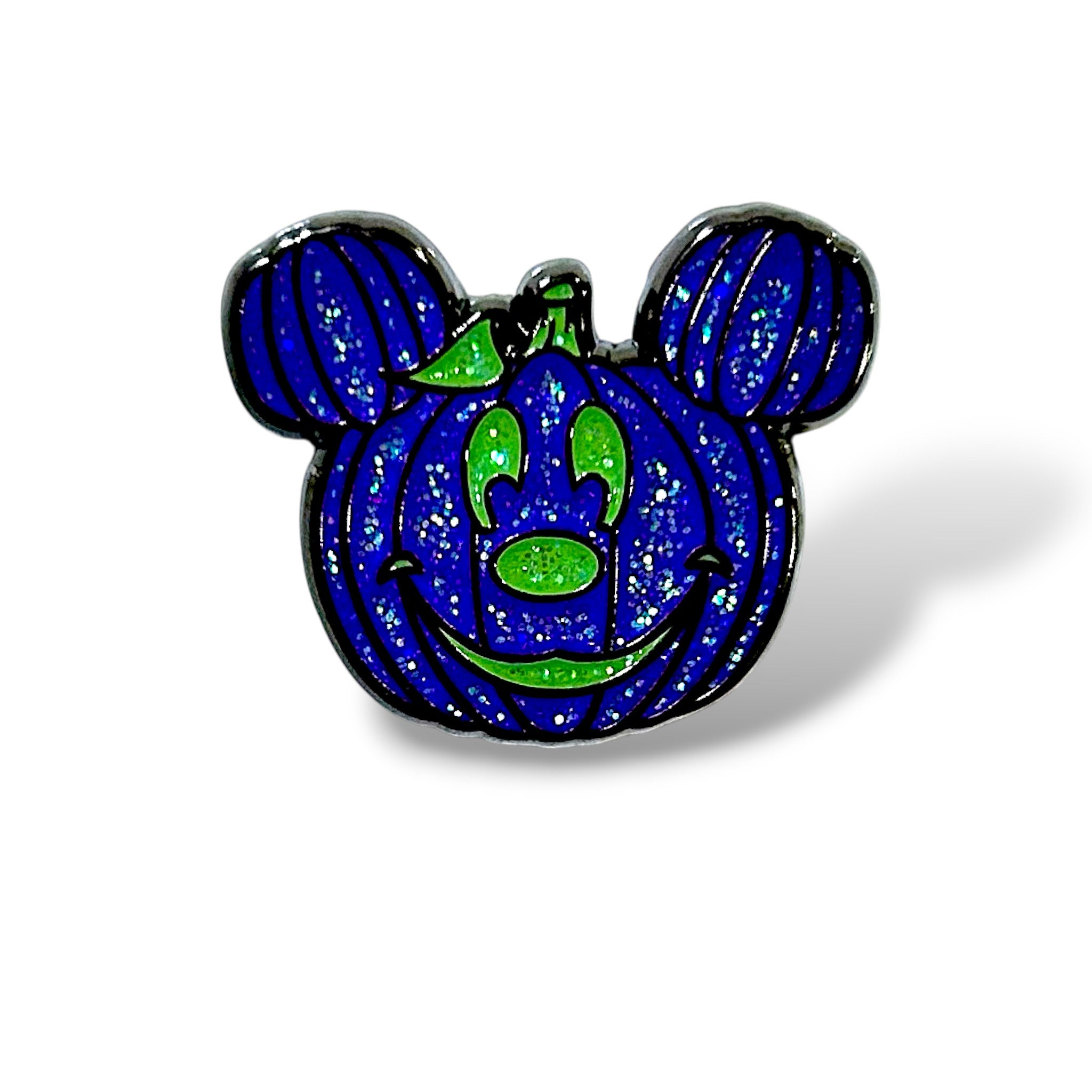 Enamel pin shaped like a dark purple glittery pumpkin with green facial features and a leaf on top, styled with round mouse ears to resemble a Halloween-themed character; designed in a whimsical, spooky cartoon style with sparkling accents.