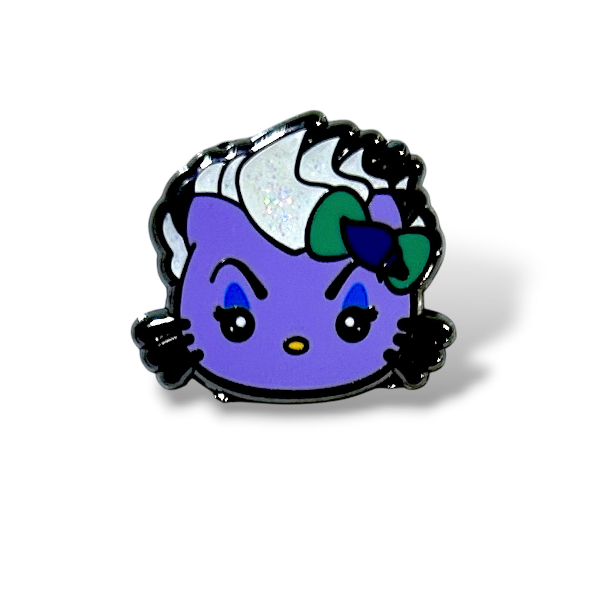 Enamel pin featuring a stylized cartoon cat character with a purple face, black whiskers, and expressive blue eyebrows angled downward; the character has split black-and-white hair styled like a sea witch, a green and blue bow on one side, a yellow nose, and glossy black eyes—designed in a spooky villain mashup theme inspired by underwater magic and mischievous royalty.